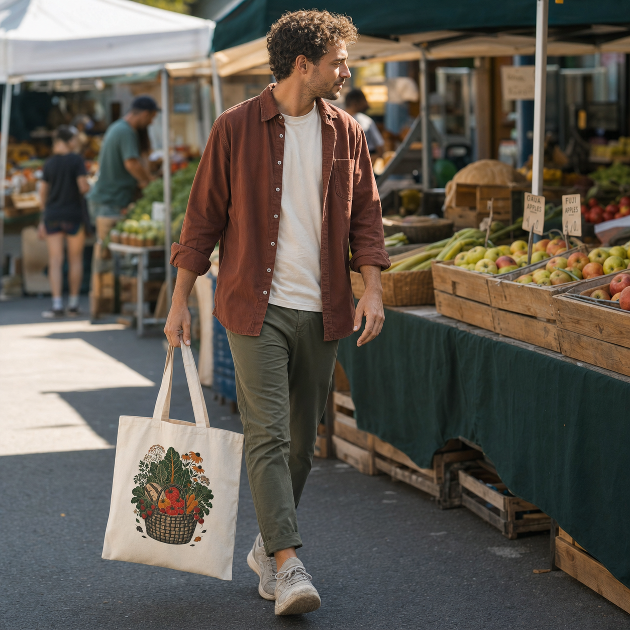 Man walking through an outdoor market carrying Farmers Market tote Side A by the handles